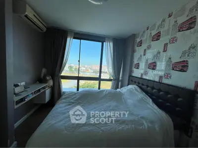 Cozy bedroom with large window and city view, featuring stylish wallpaper and modern decor.