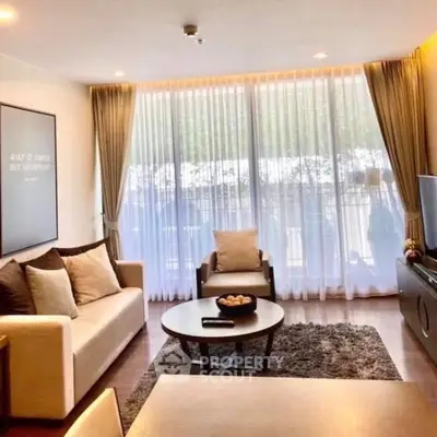 Spacious living room with large windows and modern decor, perfect for relaxation and entertainment.