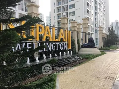 Elegant entrance of luxury apartment complex with modern architecture and water feature.