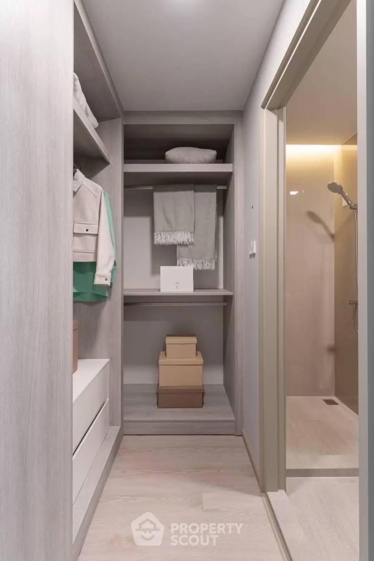 Modern walk-in closet with elegant shelving and adjacent shower area