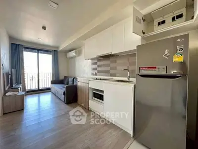 Modern open-plan living room with kitchen and balcony in a stylish apartment.