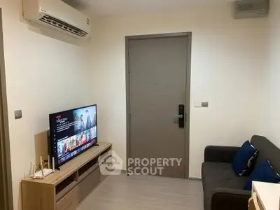 Cozy living room with modern TV setup and comfortable sofa, perfect for relaxation.