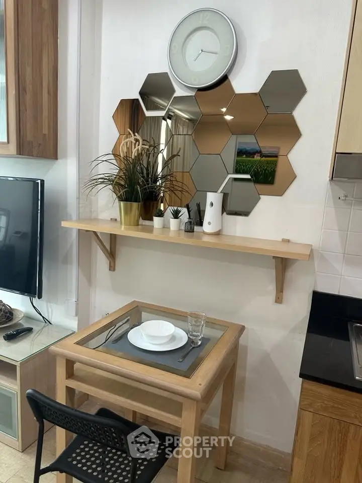Cozy dining nook with modern decor and hexagonal mirrors in stylish apartment.