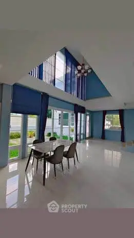 Spacious modern living room with high ceilings and large windows offering abundant natural light.