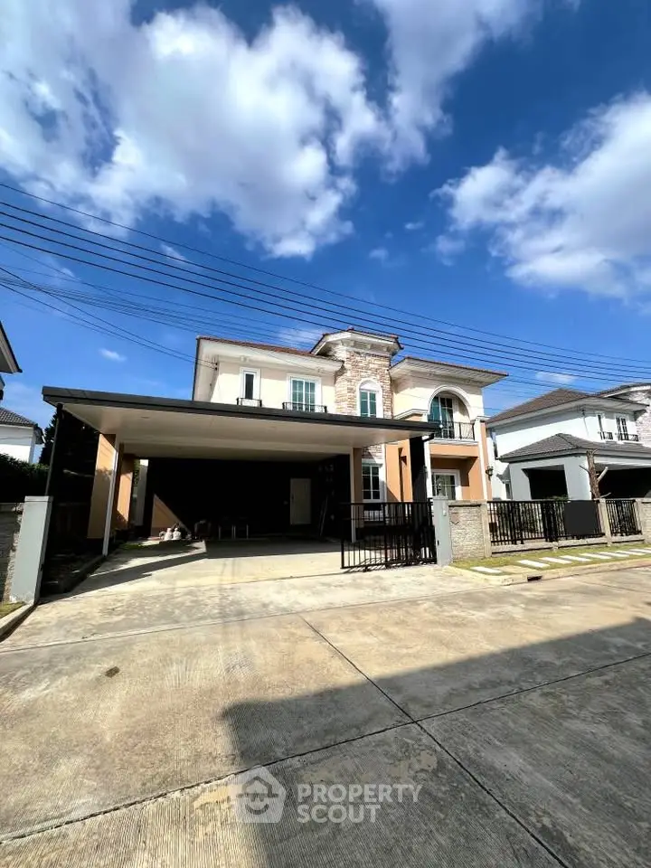 Stunning modern house with spacious driveway and elegant facade under a clear blue sky.