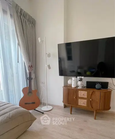 Stylish living room with modern decor, featuring a guitar and large TV for entertainment.