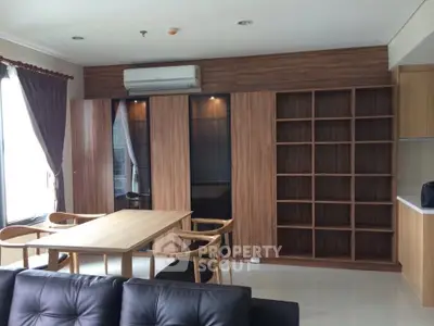 Modern living room with wooden furniture and built-in shelving, featuring a sleek air conditioning unit.