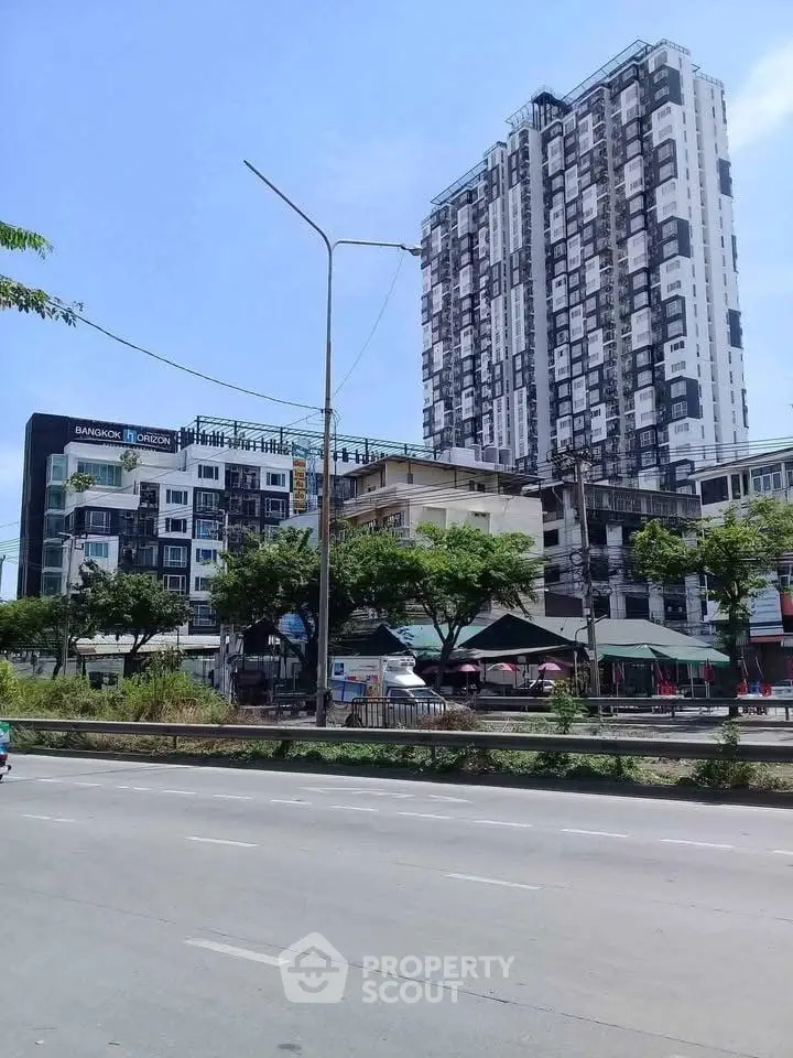 Modern high-rise building with urban street view, showcasing contemporary architecture and city living.