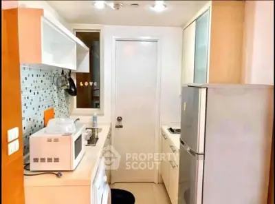 Charming compact kitchen with modern appliances and stylish backsplash in cozy apartment.