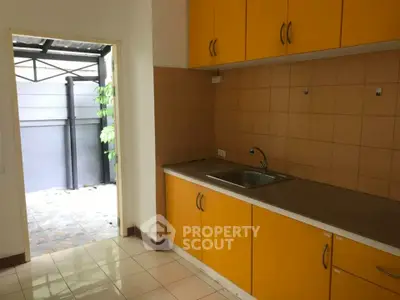 Charming kitchen with vibrant yellow cabinets and outdoor access, perfect for modern living.