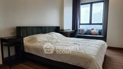 Modern bedroom with large window and cozy seating area