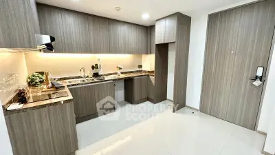 Modern kitchen with sleek cabinetry and granite countertops in a stylish apartment.