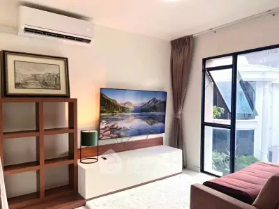 Modern living room with large window and stylish decor in a bright apartment.