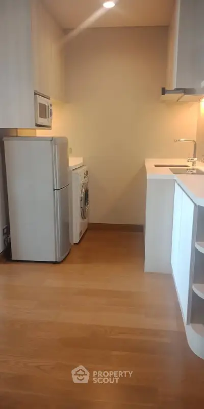 Modern kitchen with sleek appliances and wooden flooring