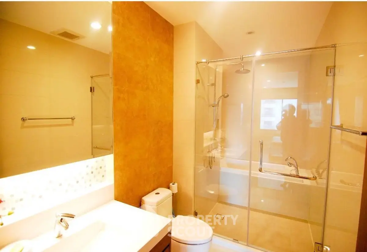 Modern bathroom with glass shower and elegant fixtures in a luxurious real estate property.
