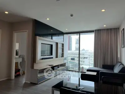Modern living room with large windows and city view, featuring sleek furniture and built-in entertainment center.