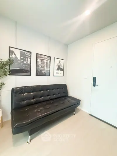 Stylish modern living room with black leather sofa and chic wall art