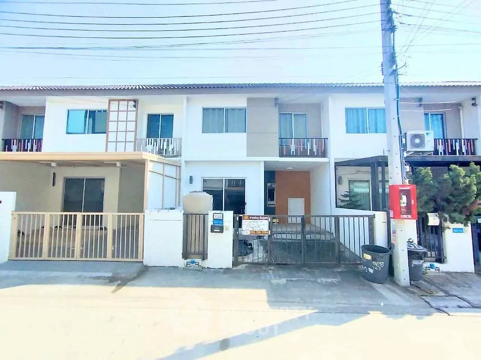 Modern townhouse exterior with gated entrance and balcony