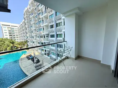 Spacious balcony with pool view in modern apartment complex