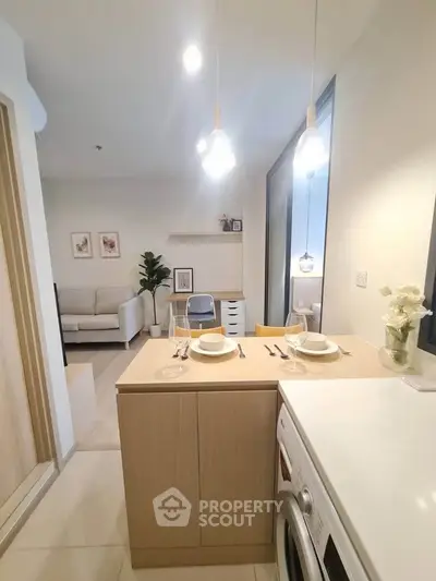 Modern open kitchen with dining area and cozy living room in stylish apartment.