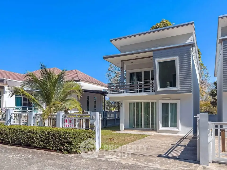 Modern two-story house with sleek design and spacious driveway in sunny neighborhood.