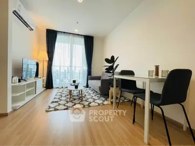 Modern living room with stylish decor and natural light, featuring a cozy sofa and dining area.