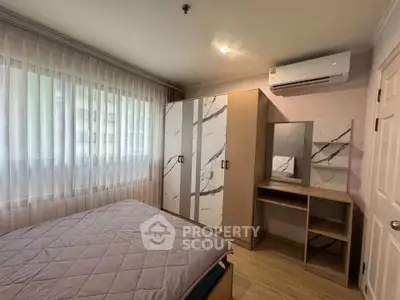 Cozy bedroom with modern wardrobe and air conditioning in a bright apartment.