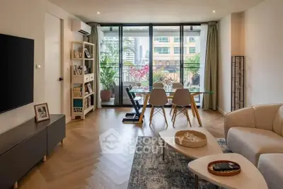 Modern living room with stylish decor and large windows offering city views.