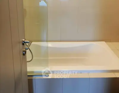 Modern bathroom with sleek bathtub and glass partition, perfect for relaxation and style.