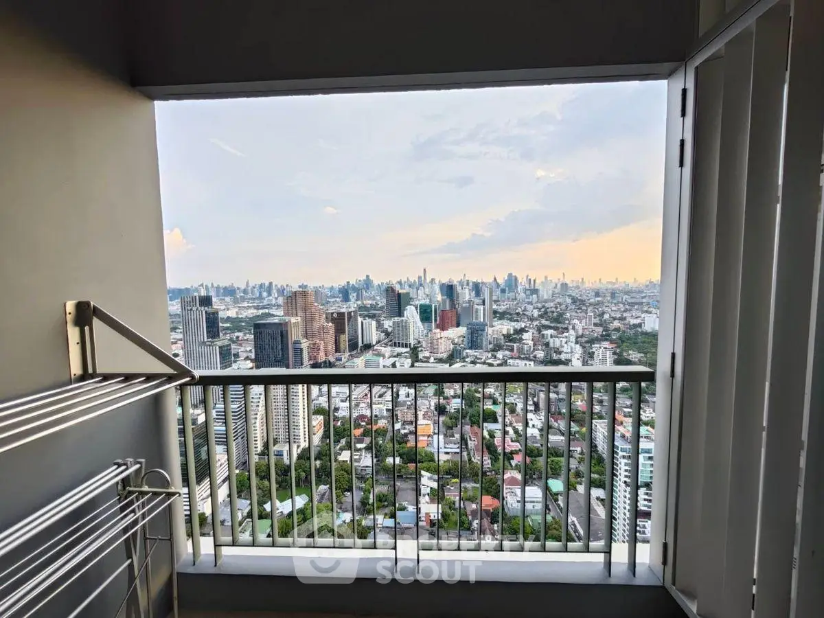 Stunning high-rise balcony view of city skyline at sunset, perfect for urban living.