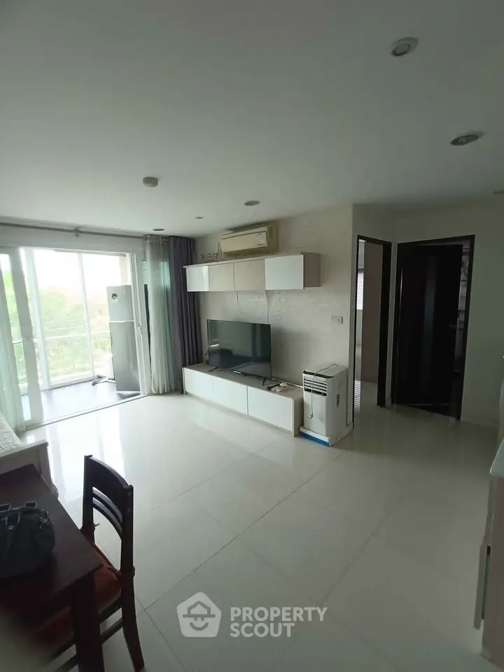 Spacious living room with modern decor and natural light, perfect for relaxation and entertainment.