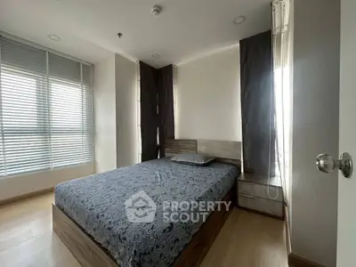 Modern bedroom with large windows and stylish decor in a contemporary apartment.