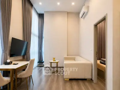 Modern living room with high ceilings, elegant curtains, and sleek furniture in a contemporary apartment.