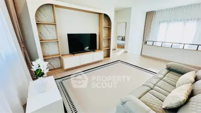 Modern living room with stylish TV unit and cozy sofa, featuring elegant decor and natural light.