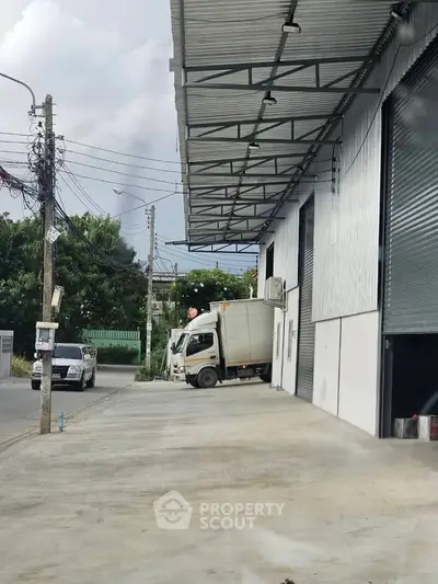 Industrial warehouse exterior with loading dock and parked truck