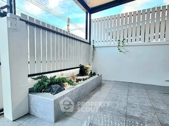 Charming small garden patio with modern tiles and decorative plants, perfect for relaxation.
