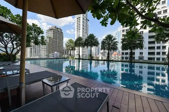 Luxurious rooftop pool with stunning city skyline views in modern high-rise building.