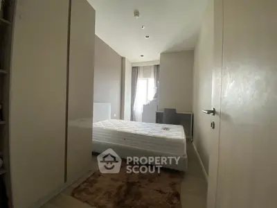 Cozy bedroom with natural light, featuring a comfortable bed and modern decor.