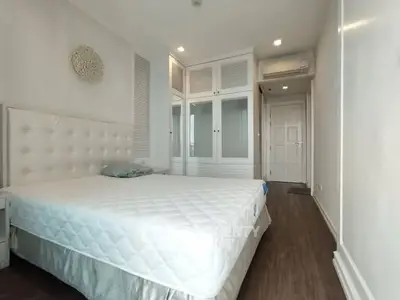 Spacious bedroom with elegant white decor and ample storage space
