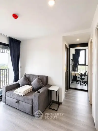 Modern living room with cozy sofa and study area in bright apartment