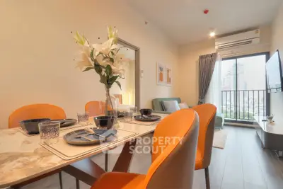 Modern dining area with elegant table setting and city view balcony.