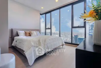 Luxurious bedroom with floor-to-ceiling windows offering stunning city views.
