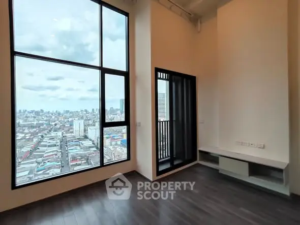 Spacious modern living room with floor-to-ceiling windows and stunning city view