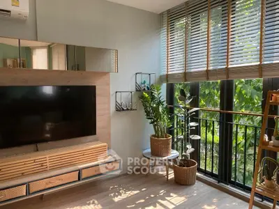 Bright living room with modern decor and large windows overlooking greenery.