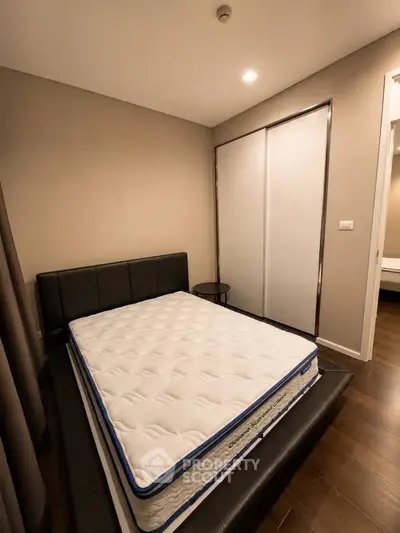 Cozy bedroom with modern design featuring a comfortable bed and sleek sliding closet doors.