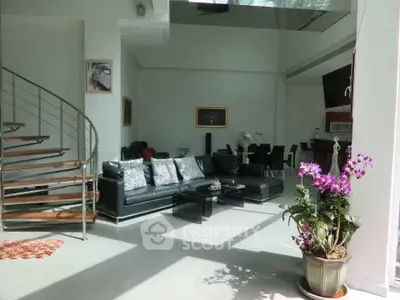 Spacious modern living room with elegant staircase and natural light