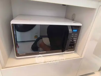 Modern kitchen with built-in Samsung microwave oven in sleek cabinetry.