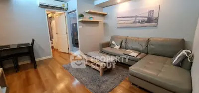 Modern living room with stylish gray sofa and wooden flooring