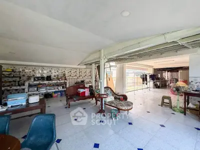 Spacious open-plan living area with vintage furniture and tiled flooring, ideal for versatile home setups.