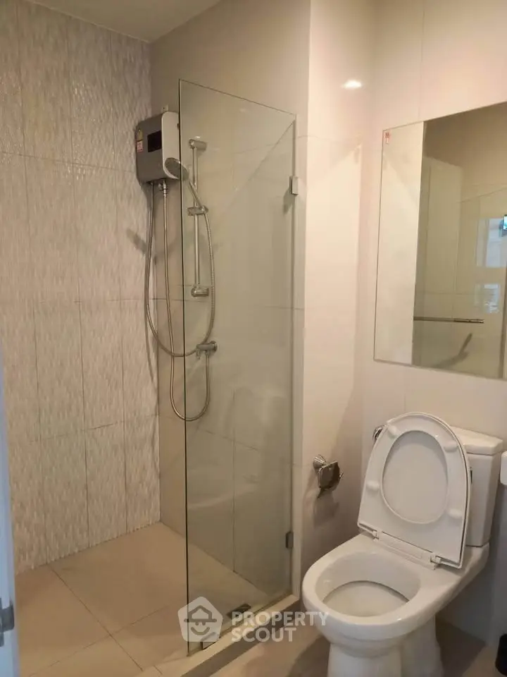 Modern bathroom with glass shower and sleek fixtures in a contemporary apartment.